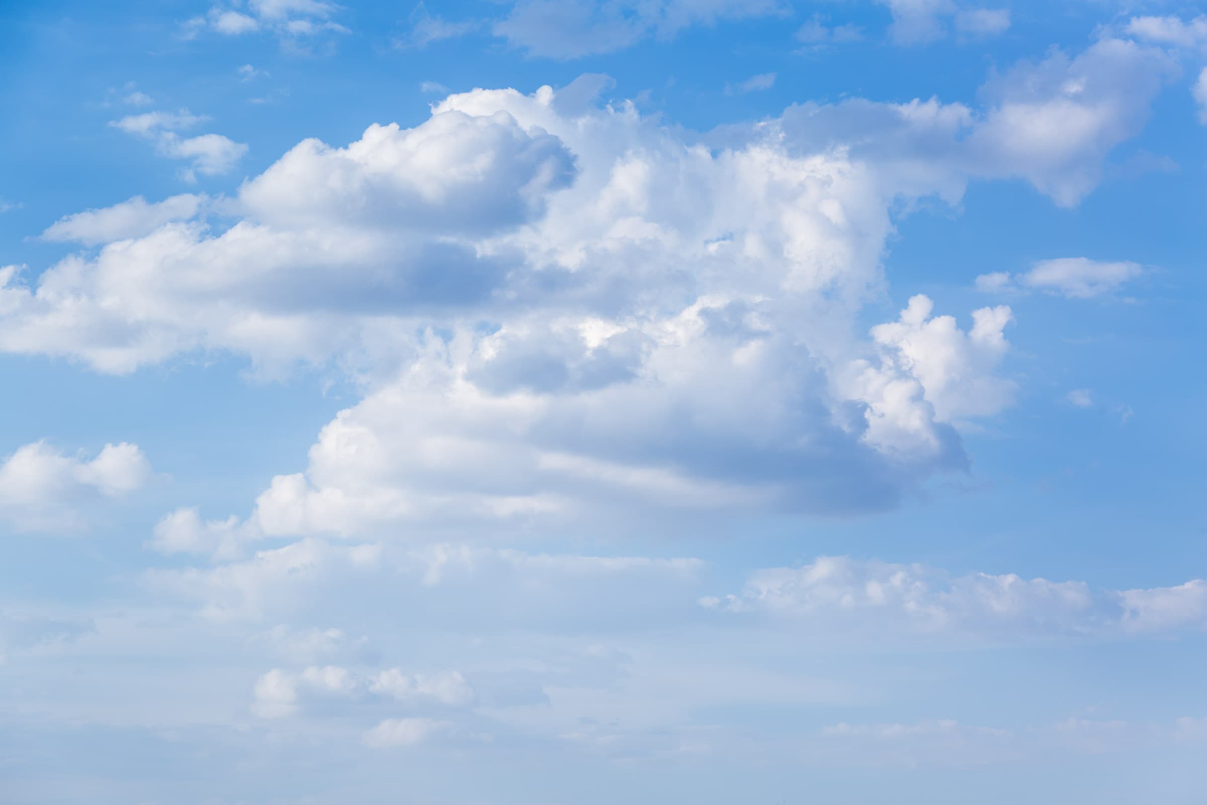 Layered white cloud formations separated against gradually changing shades of blue sky over Merritt Island, Florida, photographed by Francisco Colón.
