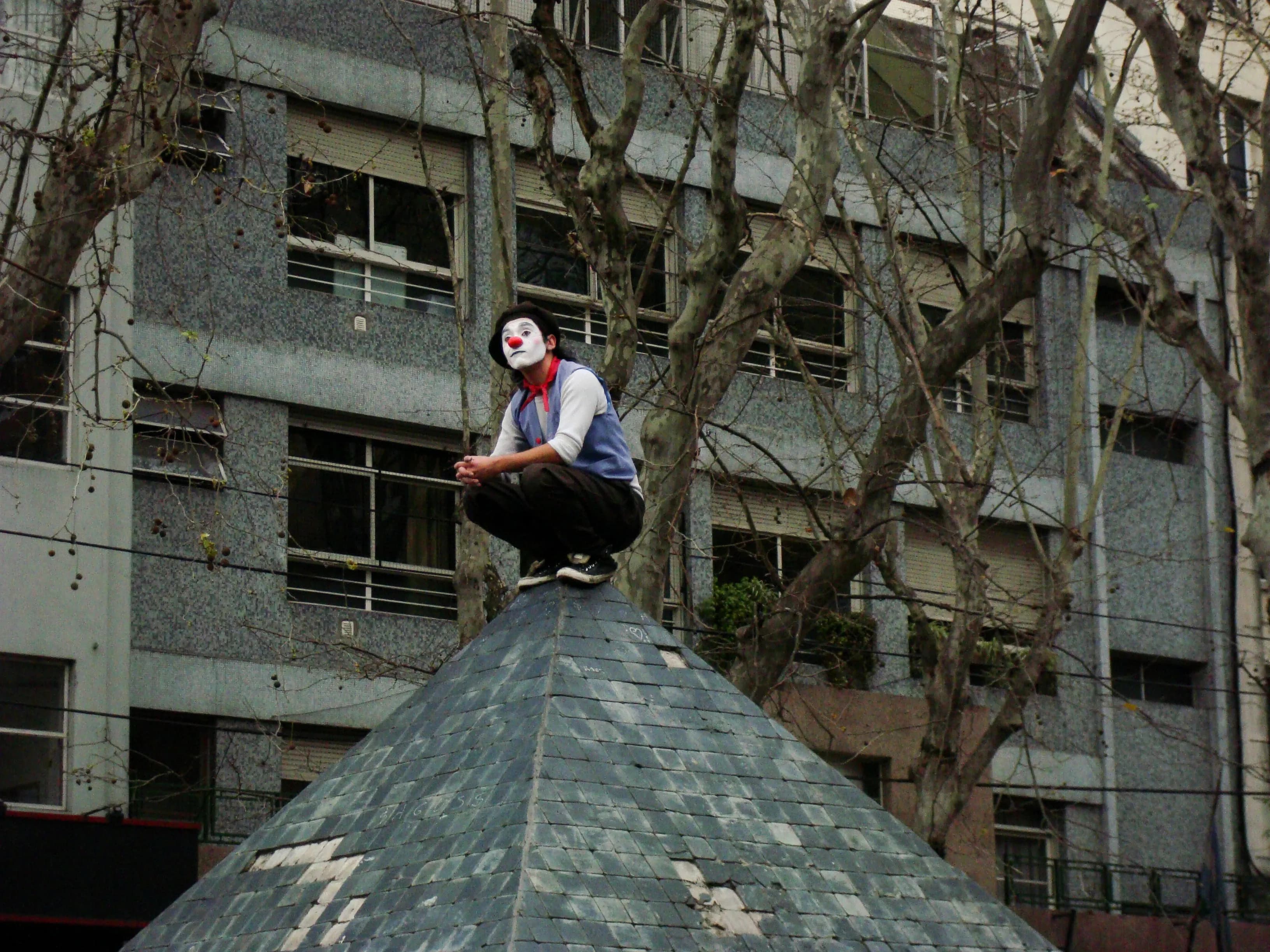 Street performer waiting quietly before entertaining passing children in San Telmo, Buenos Aires, titled Before the Laughter by Francisco Colón.