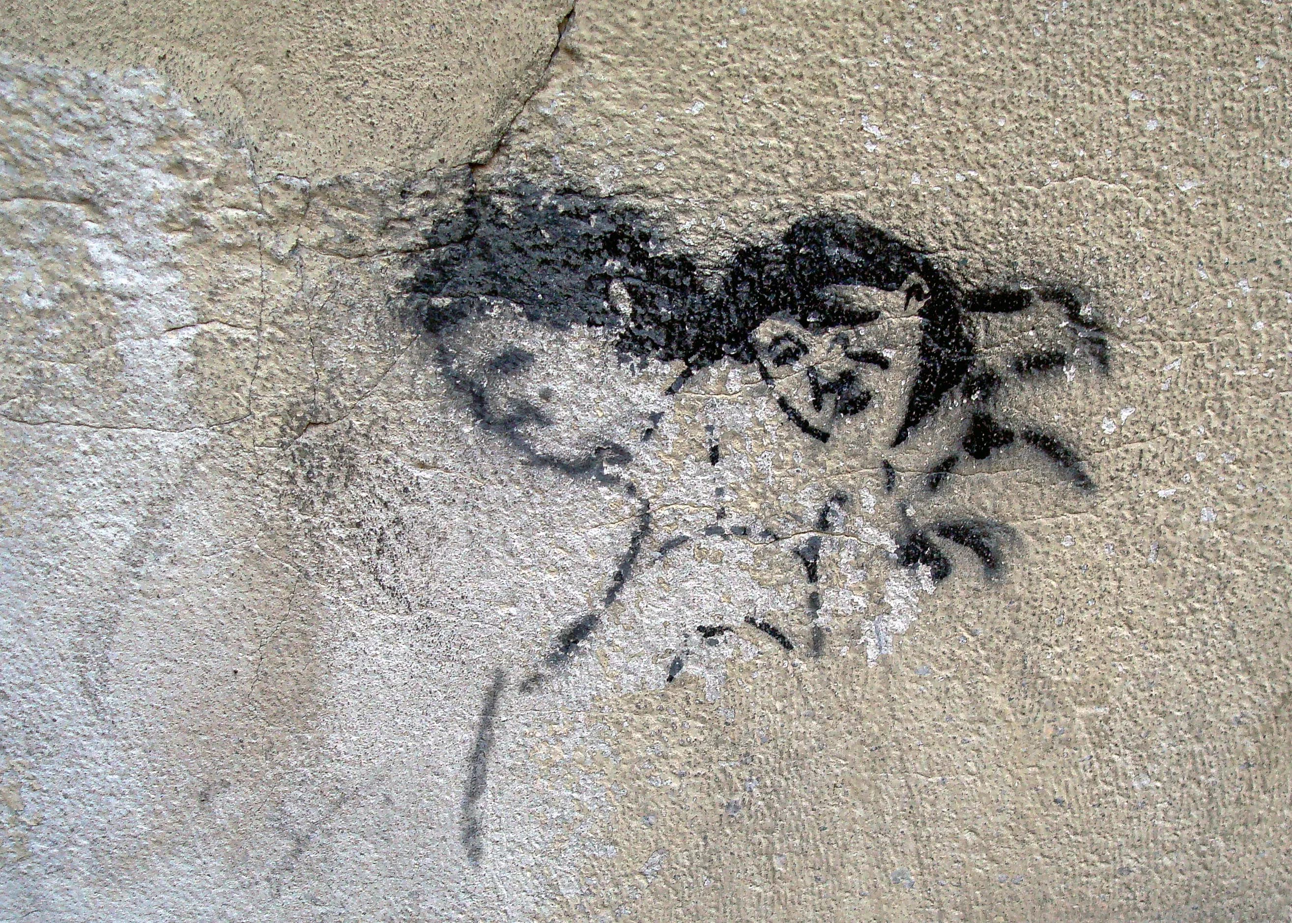 Small weathered portrait of a woman painted close to sidewalk level on a building near Alto Palermo in Buenos Aires, titled The Forgotten Muse by Francisco Colón.